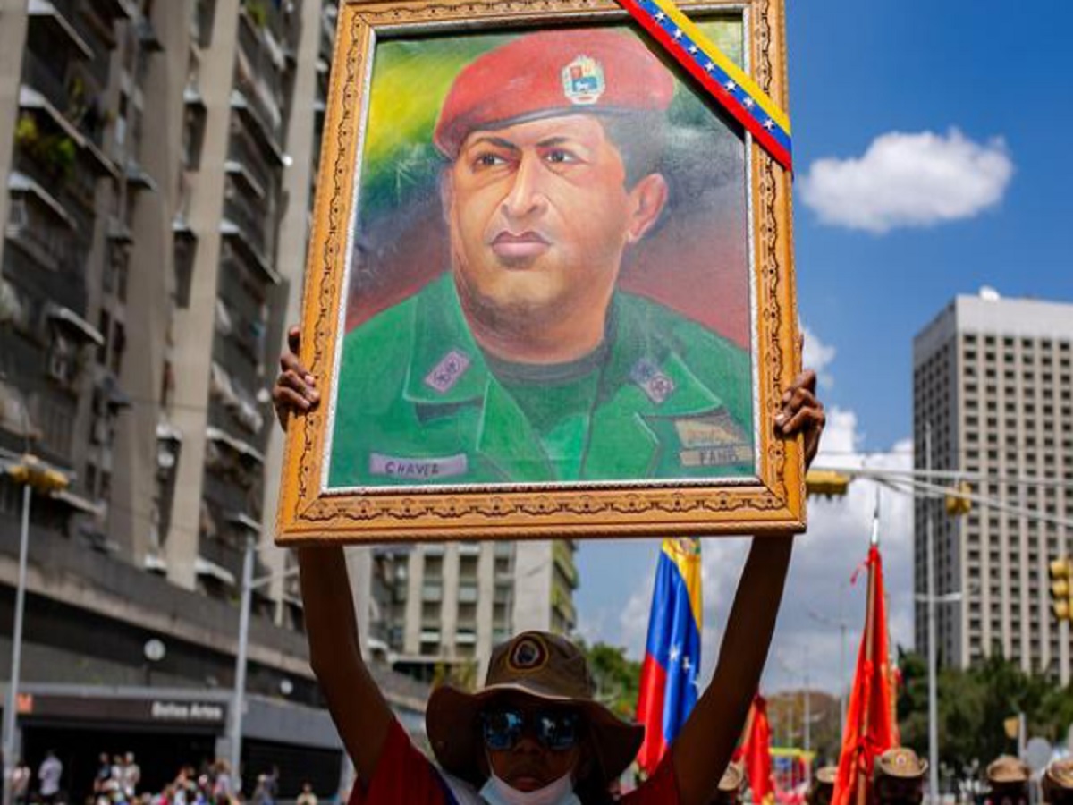 Mujer sostiene un cuadro de Chávez